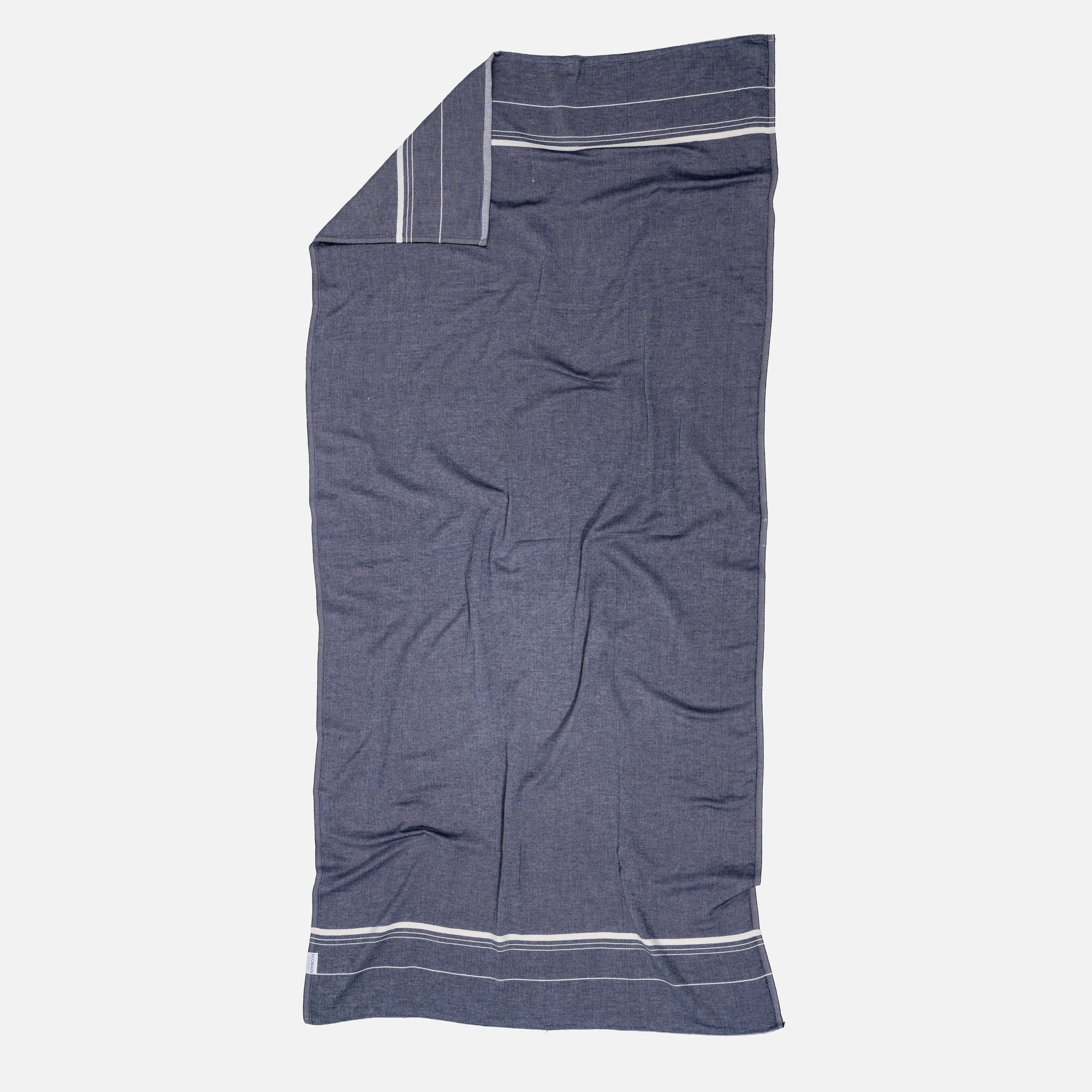 Detailaufnahme des 4-lagigen Jacquard-Musselin-Gewebes eines Ecobain 'Bathroom Cocoon' Tuchs in Midnight Anchor. Die faszinierende Webstruktur verdeutlicht die handwerkliche Qualität und verspricht ein unbeschreiblich weiches, anschmiegsames Gefühl auf der Haut. Ein Statement für bewusste, ressourcenschonende Badekultur und pure Geborgenheit im Alltag.