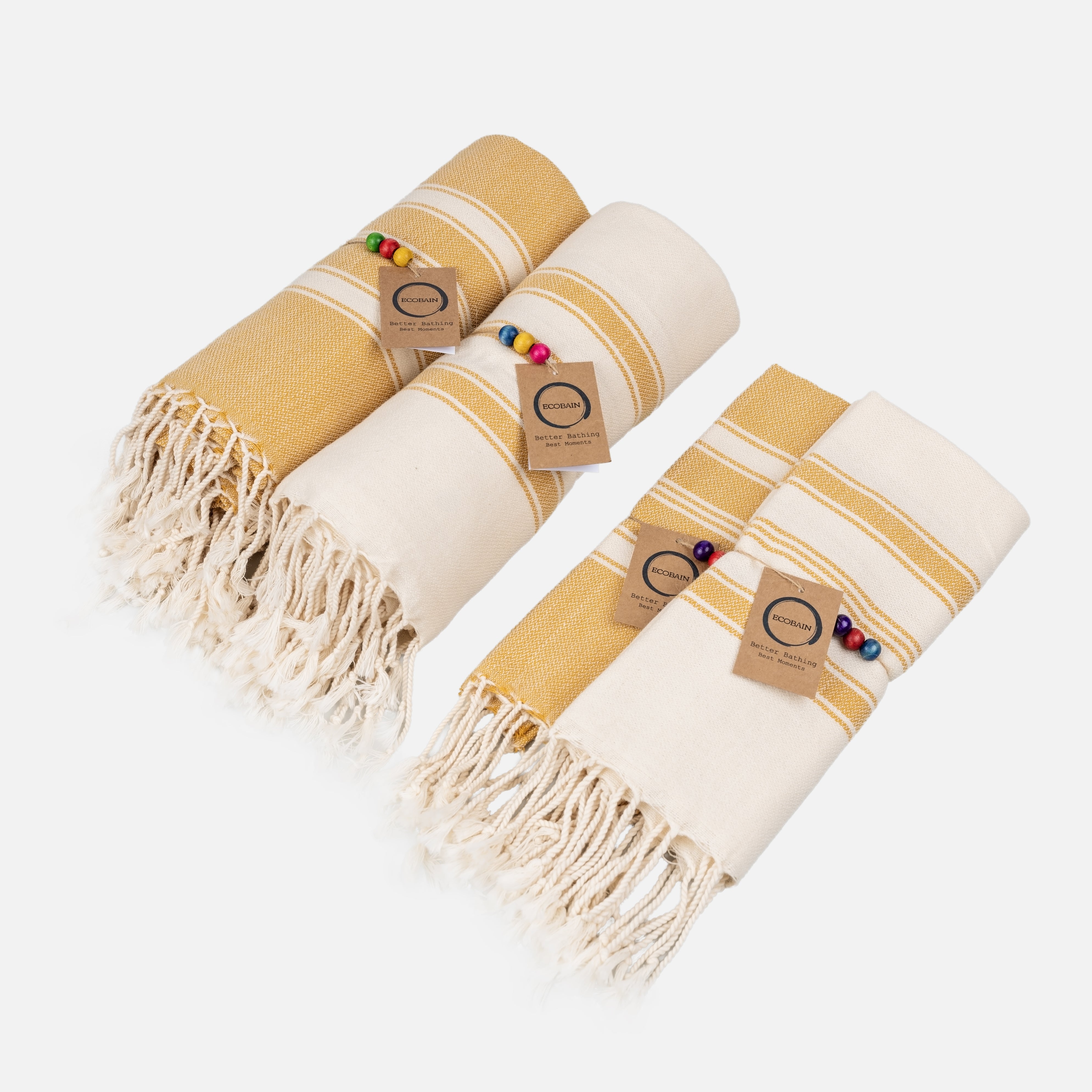 Ecobain Better Together Pack Handtuch-Set in Senfgelb und Naturweiß. Das vierteilige Hamamtuch-Set aus 100% Naturfasern besteht aus zwei großen Saunatüchern und zwei passenden Gästetüchern mit Fransen, Holzperlen und Hangtag.