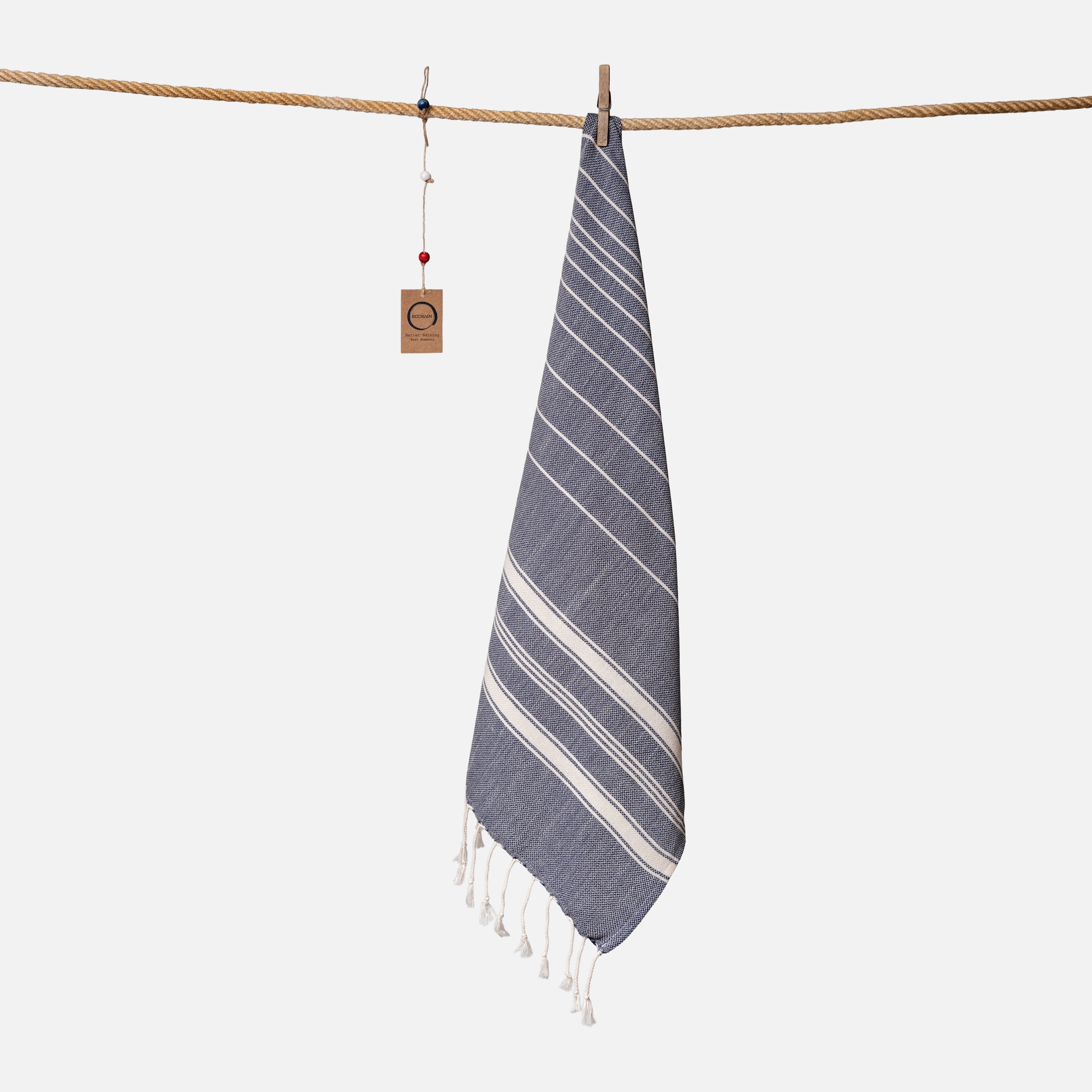 Kompaktes Ecobain Reisehandtuch im Design 'New Classic' in der eleganten Farbgebung Midnight Anchor. Mit 50x100 cm ist dieses leichte Baumwolltuch aus hochwertiger Faser der ideale Begleiter für den Ausflug zum Badesee, das Handgepäck oder als ästhetisches Sporttuch. Ein schnelltrocknendes Hamamtuch, das traditionelle Webkunst mit moderner Leichtigkeit verbindet und deinen Alltag mit purer Eleganz bereichert.