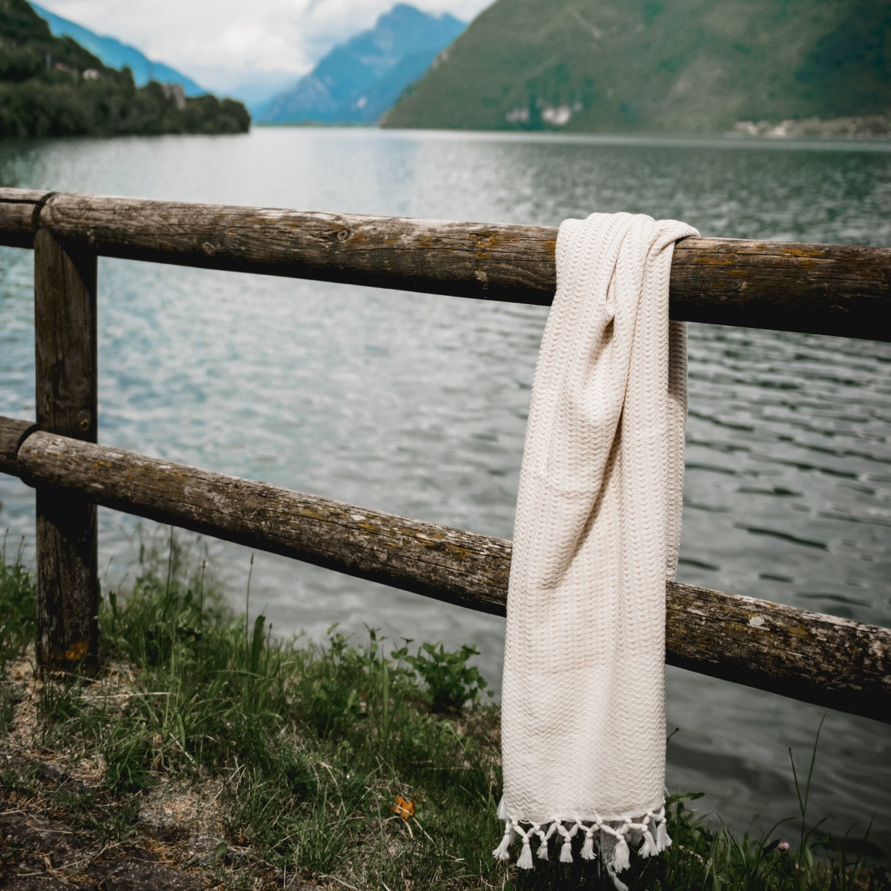 Weiches, beigegefaltetes Ecobain Gordion Towel auf Leinenstoff, Fokus auf handgeknüpfte Fransen (Fouta/Hamamtuch).