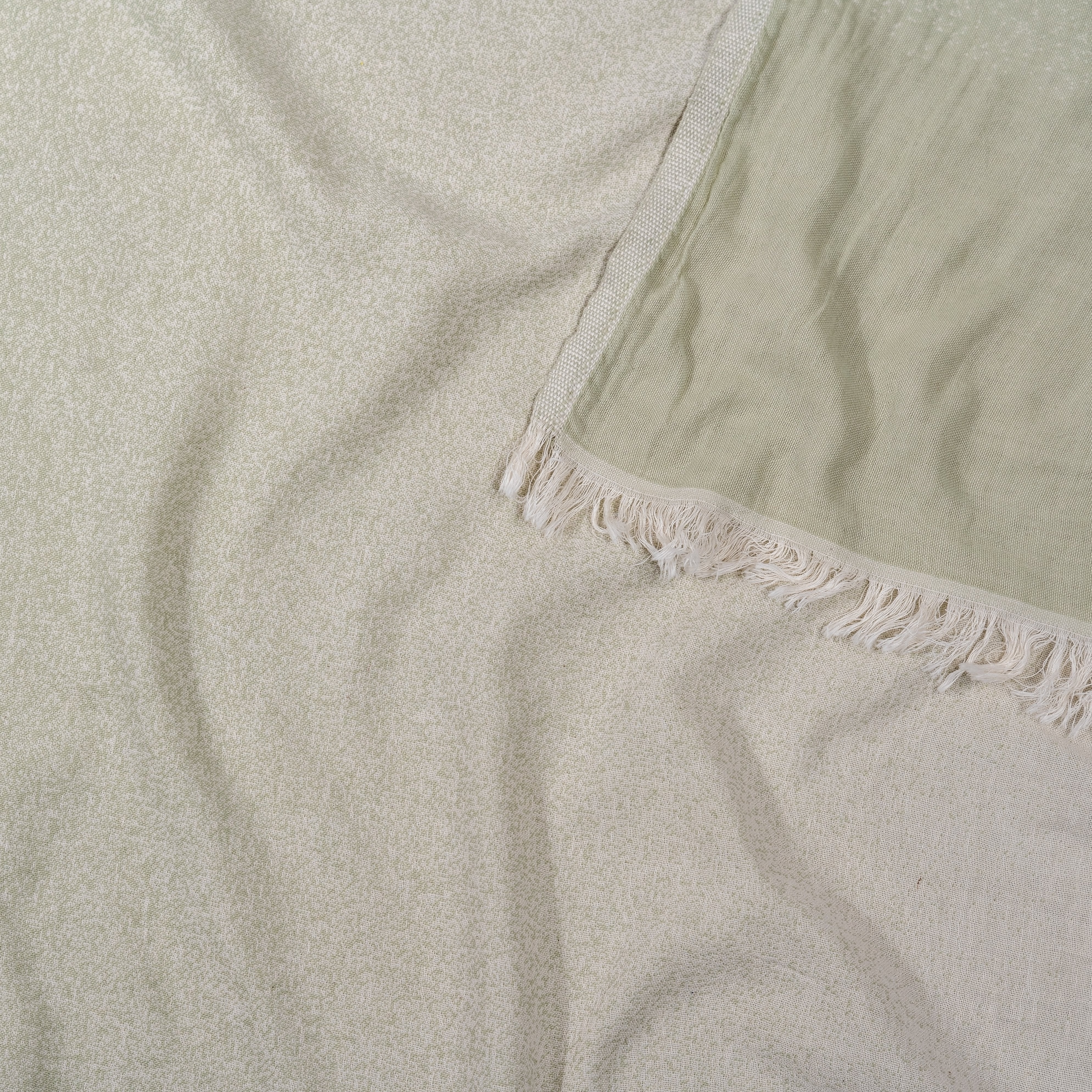 Detailansicht der Jacquard-Webung eines Ecobain Hamamtuchs, Design Faded im Farbton Magic Mermaid. Der harmonische Verlauf zwischen Salbeigrün und Ecru unterstreicht die hochwertige Verarbeitung aus 100 Prozent langstapeliger, gekämmter Baumwolle. Dieses ressourcenschonende und plastikfreie Tuch ist die smarte Alternative zu voluminösem Frottee. Extrem saugstark, schnelltrocknend und besonders hautfreundlich. Ein ästhetisches Must-have für Wellness, Yoga und ein bewusstes Zuhause.
