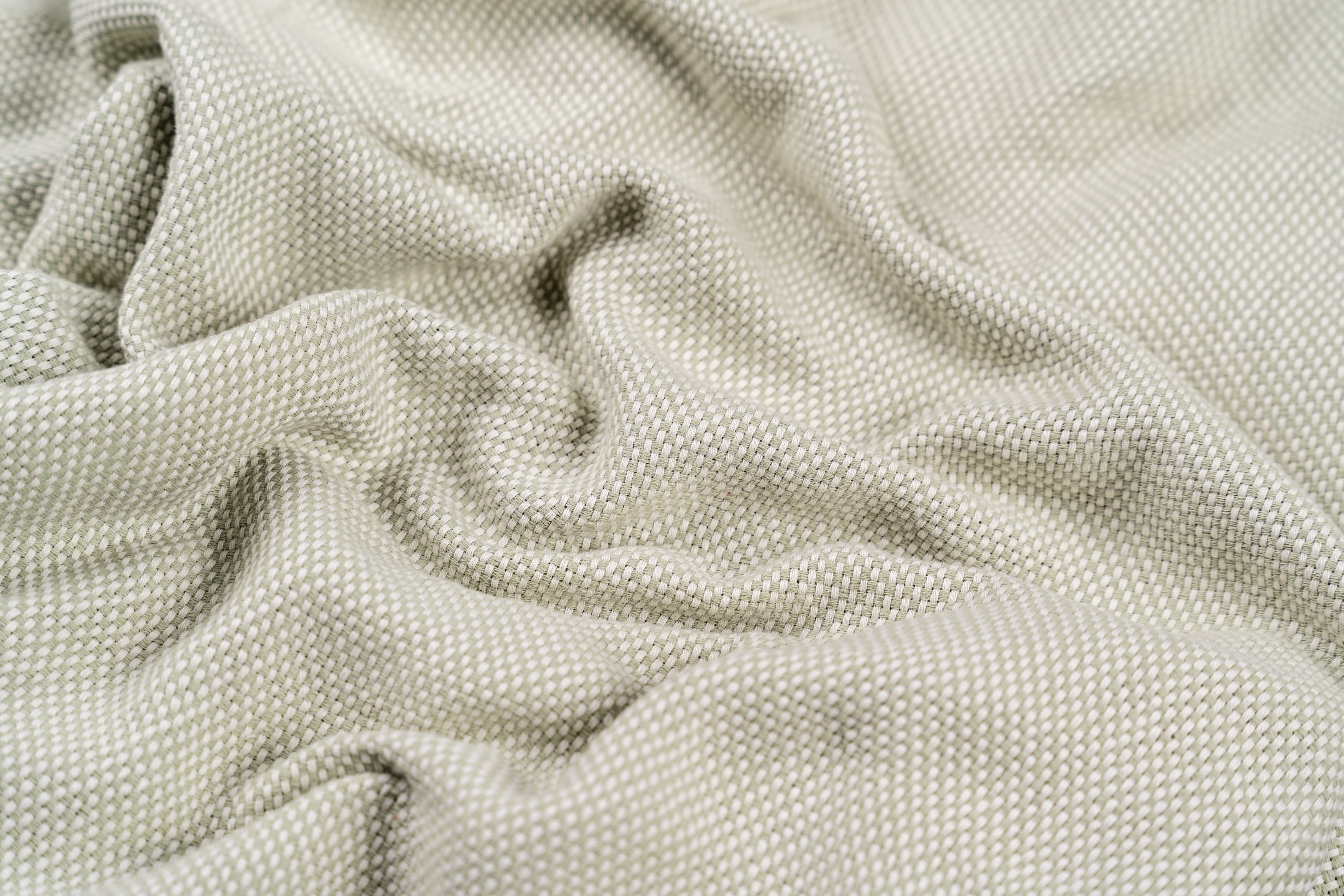 Detailansicht der robusten und griffigen Webstruktur des Ecobain Grit Towels. Die natürliche, strukturierte Oberfläche bietet eine wohltuende Haptik und überzeugt durch ihre Langlebigkeit. Gefertigt aus 100 Prozent gekämmter Baumwolle, ist dieses ressourcenschonende Tuch die smarte, plastikfreie Alternative zu schwerem Frottee. Besonders saugstark, schnelltrocknend und ein langlebiger Begleiter für ein intensives Baderitual, Sport oder die tägliche Wellness-Routine.
