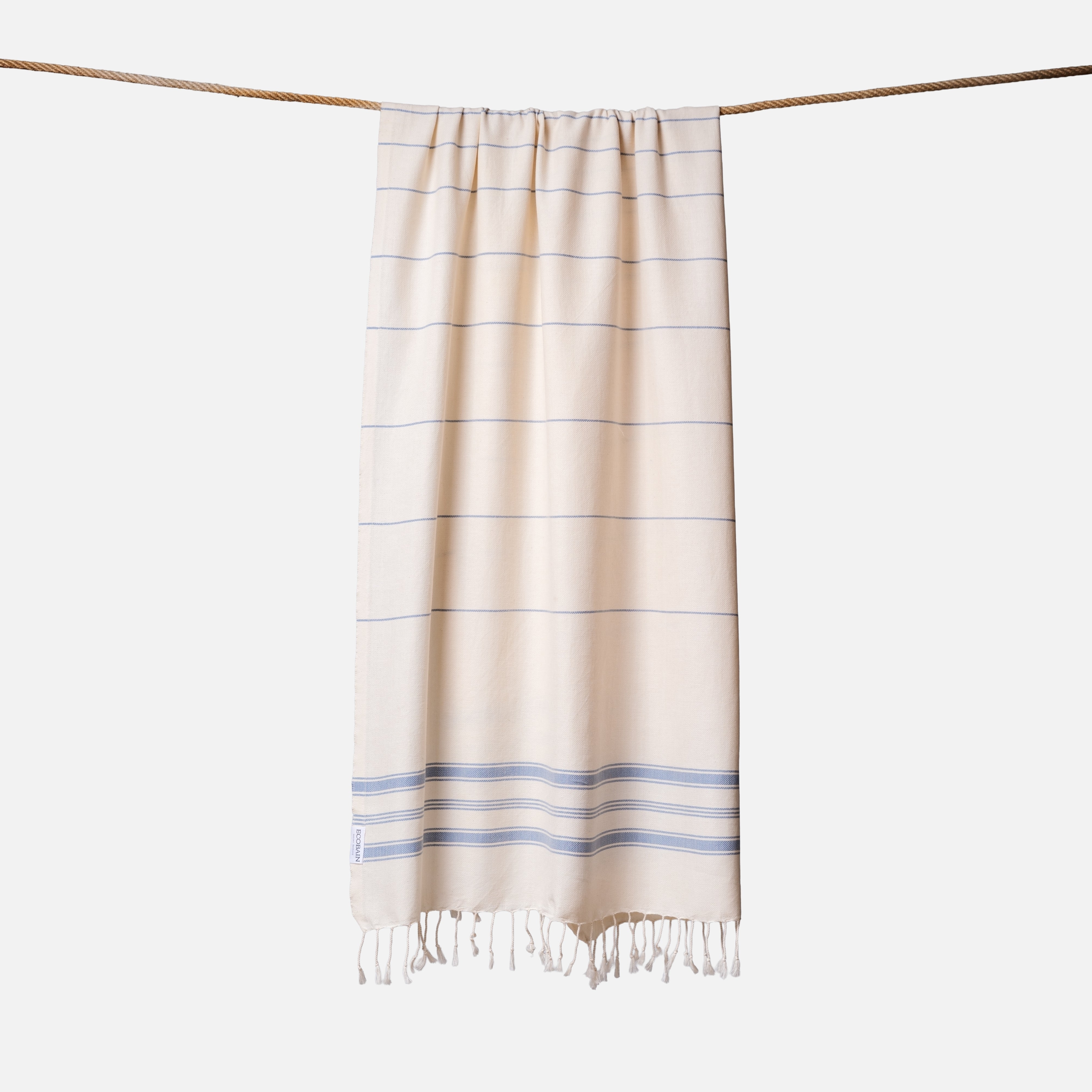 Extragroßes Ecobain Strandtuch der Liberty Series in maritime Blau Fair Winds. Dieses leichtgewichtige Pestemal in 100x200 cm ist das ultimative Reisehandtuch für Segler, Camper und Vanlife-Enthusiasten. Es trocknet blitzschnell, lässt sich extrem kompakt verstauen und ersetzt im Koffer oder Camper das schwere, platzraubende Frottee. Ein plastikfreies Must-have aus pestizidfreiem Anbau, das mit dir durch dick und dünn geht.