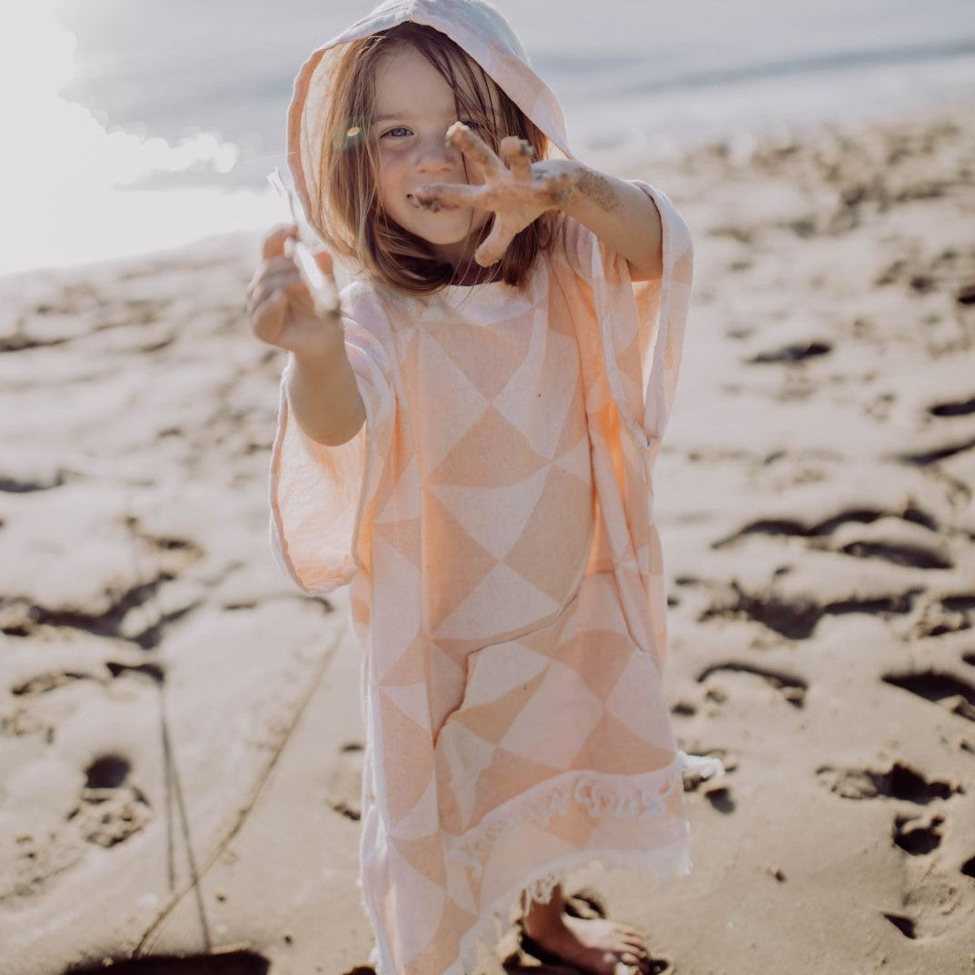 Detailansicht des Ecobain Ponchos Symique in Soft Peach, die das weiche, doppellagige Jacquard Gewebe zeigt.